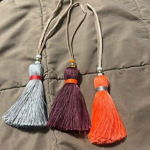 Set of Three India Hicks tassels in orange, gray and wine colors. 11” long
